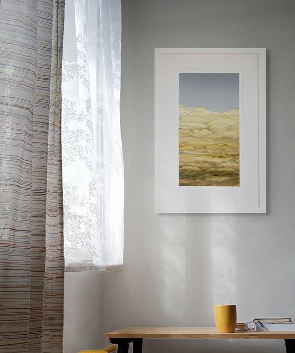 Framed abstract art on a gray wall with a window and curtain in the background