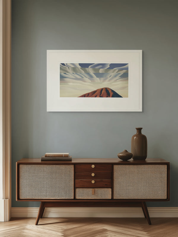 Framed artwork on a wall above a wooden sideboard with decorative items.