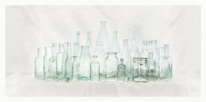 Collection of various vintage glass bottles on a light background