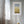 Framed abstract art on a gray wall with a window and curtain in the background