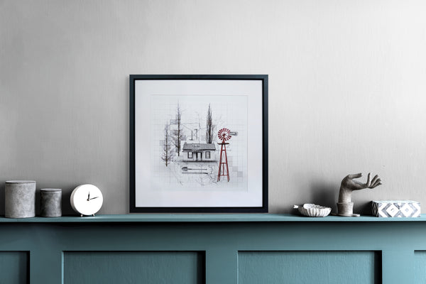 Framed artwork on a shelf against a plain wall