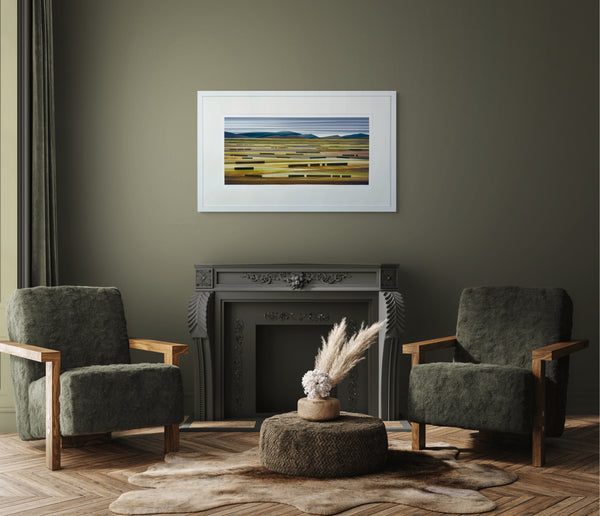 Two green armchairs in a living room with a fireplace and framed artwork on the wall.