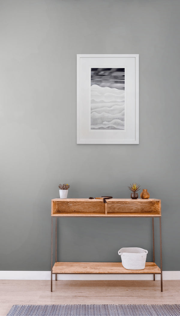 Wooden console table against a gray wall with a framed picture above it.